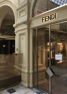 an entrance to a building with glass doors and windows on both sides that say fendi