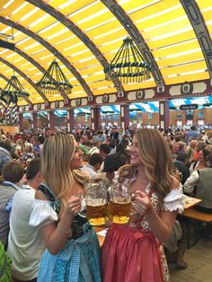 two women in costume drinking beer at an event