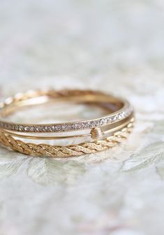 two gold wedding bands with diamonds on them