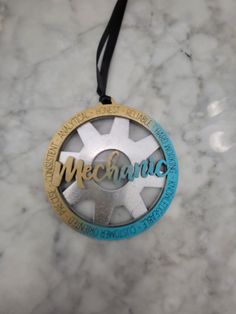 a medal that is on top of a marble surface with the word mecumnic written in gold and blue