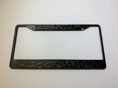 a black license plate frame with an animal print design on the front and back side