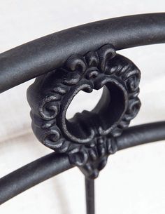 an ornate iron bed frame with black paint