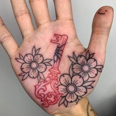 a person's hand with a tattoo on it holding a guitar and flowers in the palm