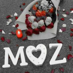 a bouquet of flowers is laying on the ground next to a sign that says moz