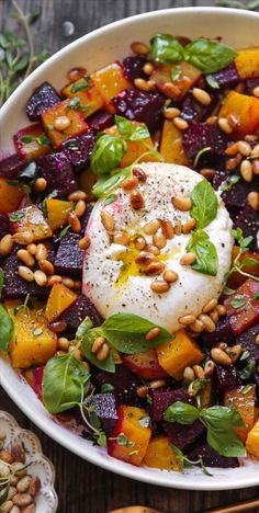 a white bowl filled with beets, spinach and poached egg on top