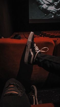 someone is sitting in the theater with their shoes on