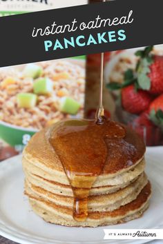 stack of pancakes with syrup and strawberries in the background