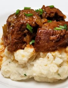 a white plate topped with mashed potatoes and meat