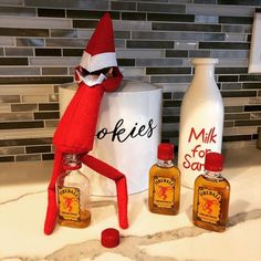 an elf is standing next to two bottles