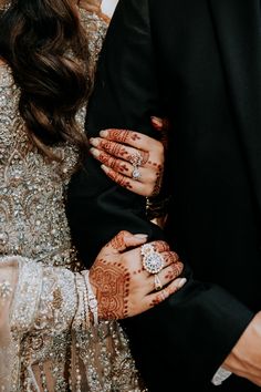 the bride and groom are holding each other's hands with their arms wrapped around them