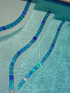 an empty swimming pool with blue tiles on the edge and water running down it's sides