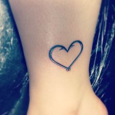 a small heart tattoo on the ankle