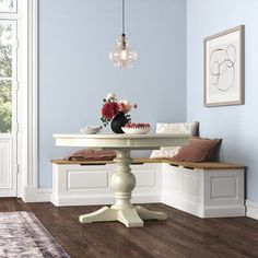 a dining room with blue walls and wood flooring is pictured in this image, there are two benches on either side of the table