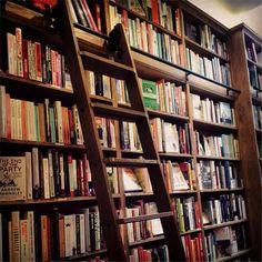 a ladder leaning up against a bookshelf filled with lots of different colored books