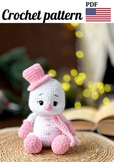 a small crochet bunny sitting on top of a table next to an open book