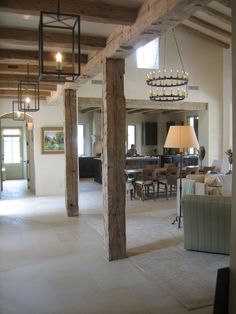 a living room filled with lots of furniture and a chandelier hanging from the ceiling