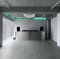 an empty room with white walls and green lighting on the ceiling is pictured in this image