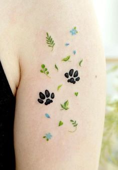 a woman with tattoos on her arm and paw prints painted on the back of her arm