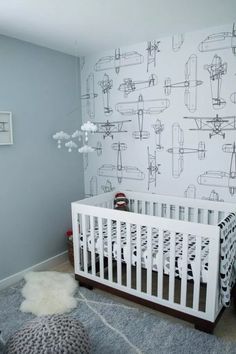 a baby's room with a crib and wallpaper