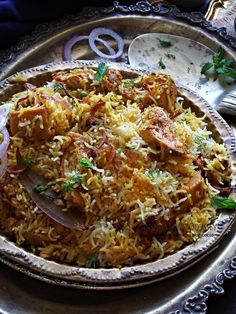 a silver plate topped with rice and meat