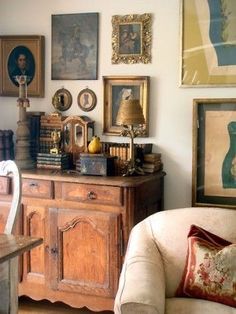 a living room filled with furniture and pictures on the wall next to a wooden table