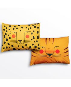 two pillows with leopard faces on them, one is yellow and the other is orange