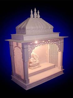 a small white shrine with a buddha statue in the center and lights on it's sides