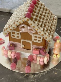 a gingerbread house with pink and yellow candies around it