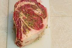 a piece of raw meat sitting on top of a cutting board