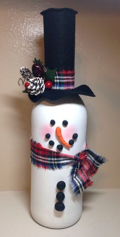 a snowman with a top hat and scarf on it's head is standing in front of a wall