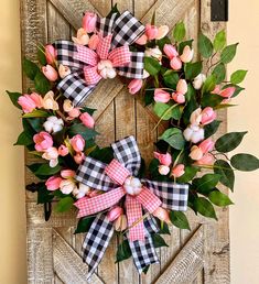 a wreath with pink flowers and green leaves