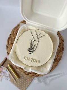 a cake in a box with the word mom engraved on it and a gold fork next to it