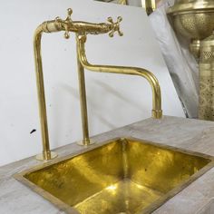 a gold sink in the middle of a counter top with a golden faucet