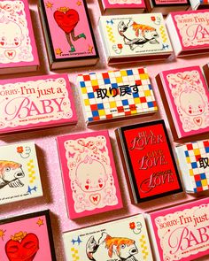 many cards are arranged on a pink surface with red and white lettering that says, you're just a baby