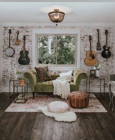 a living room with guitars on the wall and a couch in front of a window