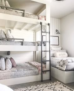 a bedroom with bunk beds and pillows on the bottom floor, along with a rug