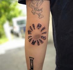 a man with a tattoo on his arm has a clock and bones in the middle