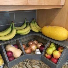 an assortment of fruits and vegetables are arranged in the corner of a kitchen countertop