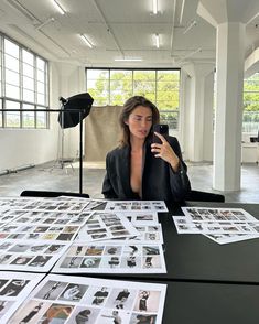 a woman sitting at a table with many photos on it