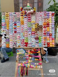 a woman standing in front of a display of bracelets and hair clips on a easel