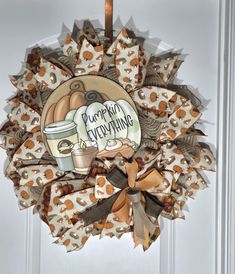 a wreath hanging on the front door decorated with coffee cups and pumpkins, says pumpkin everything