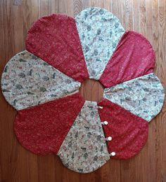 four pieces of fabric laid out in the shape of a flower on a wooden floor