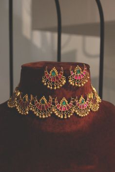 Ruby Red and Emerald Green Delicate Gold Plated Kundan Polki Bridal Indian Choker Necklace Set with Half Moon Studs Earrings embellished with Gold Beads inspired by Sabyasachi style jewellery. Faux glass polki and gold beads embellished Gold Plated Kundan Polki Bridal Indian Choker Necklace Set with half moon studs Earrings highlighted with faux red and green glass polki. Indian jewellery set, Indian Choker necklace set, Indian bridal jewellery, Indian wedding jewellery. Indian Necklace Set with Chandbali earrings, indian choker set, studs earrings, chand hand moon earrings, delicate indian necklace. Gold Plated Uncut Kundan Polki Necklace Set with studs Earrings embellished with ruby red and emerald green faux glass polki. Royal Indian Kundan choker NecklaceEarrings Set featuring round an Indian Choker Necklace Set, Bridal Indian, Indian Choker, Indian Choker Necklace, Choker Necklace Designs, Gold Necklace Indian, Gold Necklace Indian Bridal Jewelry