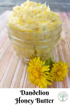 dandelion honey butter in a glass jar next to flowers on a wooden table