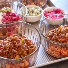 bowls filled with food sitting on top of a metal tray