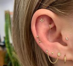 a close up of a person's ear with two piercings on it and one behind the ear