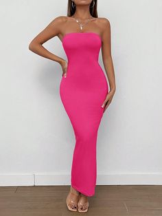 a woman in a bright pink dress posing for the camera with her hands on her hips