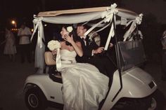 a newly married couple riding in a golf cart