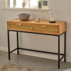 a wooden table with a bowl on it and a clock sitting on top of it