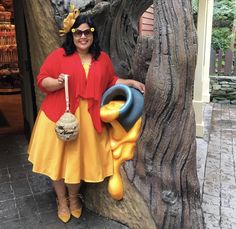 a woman standing next to a tree holding a basket